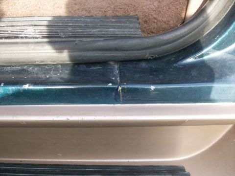 1995 Ford C-350 (Centurion Conversions) - Close-up of a car's interior door sill and rubber seal.