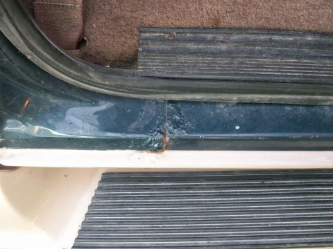 1995 Ford C-350 (Centurion Conversions) - Door sill rust and step plate detail on a vehicle.