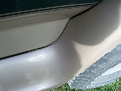 1995 Ford C-350 (Centurion Conversions) - Close-up view of a vehicle's side panel, showing wear and a portion of the tire.