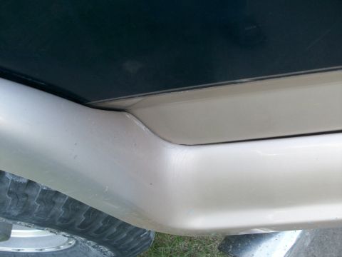 1995 Ford C-350 (Centurion Conversions) - Detail shot of a vehicle's lower body panel and tire, showing wear and tear.
