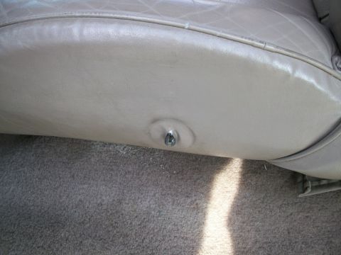 1995 Ford C-350 (Centurion Conversions) - Detail of a beige leather seat's trim and a visible metal fastener.