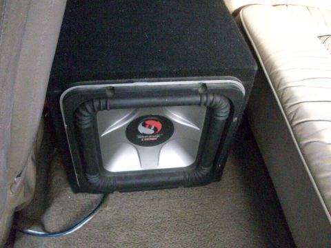 1995 Ford C-350 (Centurion Conversions) - A Kicker subwoofer is installed in the back seat area of a vehicle.