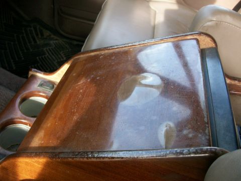 1995 Ford C-350 (Centurion Conversions) - Interior view of a vehicle's center console, wood-grain trim and cup holders.