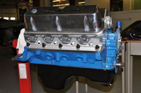 1996 Ford Bronco - A blue Ford Racing engine with chrome valve covers is mounted on a red engine stand, ready for installation or rebuild.