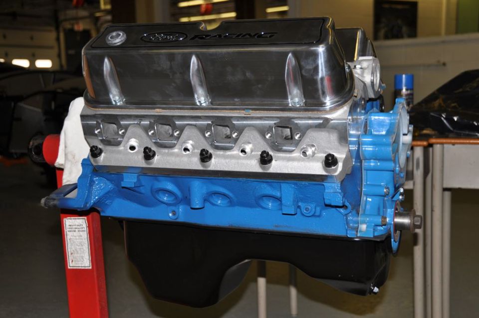 Blue Ford Racing engine with chrome valve covers on a red stand