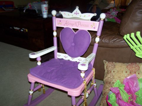 1978 Ford Bronco - A child's rocking chair with purple cushions and crown detailing is shown in a living room setting.