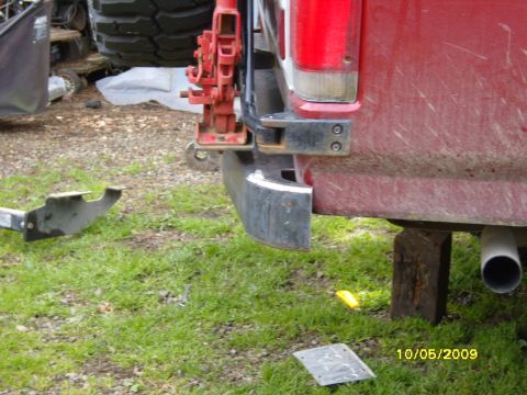 1989 Ford Bronco - Close-up of a vehicle's rear bumper and a jack, with a metal bracket nearby.