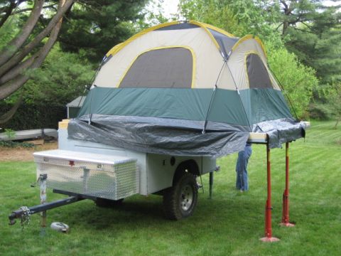 1996 Ford Bronco - A pop-up camper trailer is set up in a grassy yard, a large tent extension.