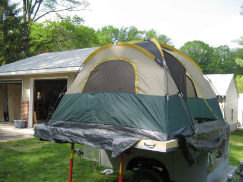 1996 Ford Bronco - Tent is mounted on a trailer, which is parked in a driveway next to a garage.
