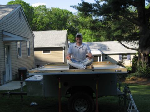 1996 Ford Bronco - A man sits on the frame of a trailer, which appears to be under construction or modification.