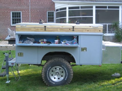 1996 Ford Bronco - A utility truck bed is shown with its storage compartments open, revealing various items inside.