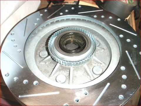 2007 Ford Mustang - A close-up view of a vehicle's brake rotor and hub assembly, showing the drilled and slotted design.