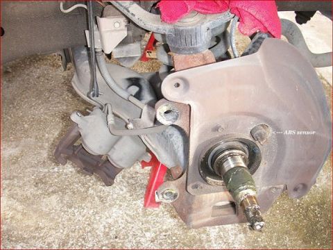2007 Ford Mustang - Close-up of a vehicle's brake assembly, showing the ABS sensor and rotor mounting area.