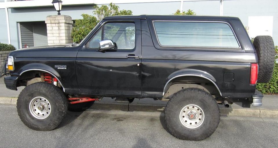 Side profile of a lifted black Ford Bronco on large tires