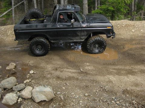 1992 Ford Bronco - This black 1978 Ford Bronco navigates a muddy trail with its spare tire secured in the cargo area.
