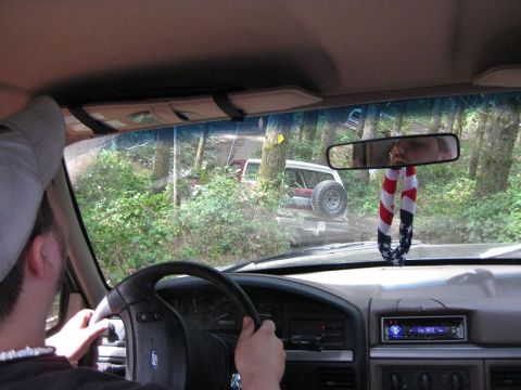 1992 Ford Bronco - Two vehicles navigate a wooded trail, with one seen from the driver's perspective and the other ahead.