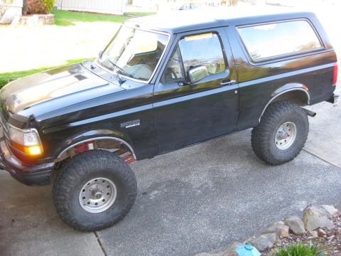 1992 Ford Bronco - 1992 Ford Bronco parked on a concrete driveway with modified suspension.