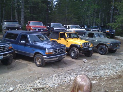 1992 Ford Bronco - Several SUVs and trucks are parked together in an outdoor setting.