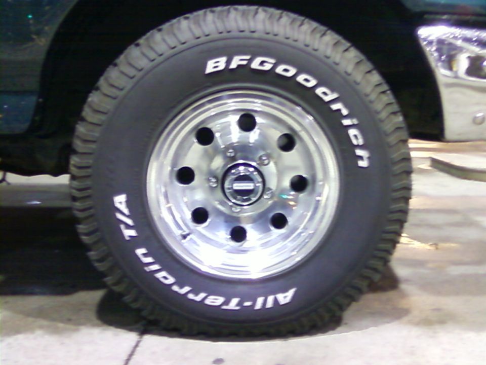 Green vehicle's front wheel with BFGoodrich All-Terrain T/A tires and chrome rim