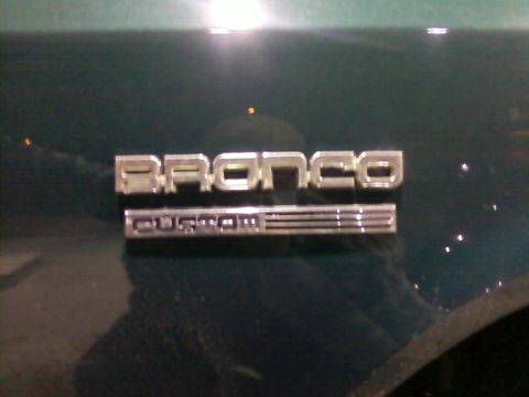 1990 Ford Bronco - Close-up of the 'Bronco Custom' badge on the side of a vehicle.