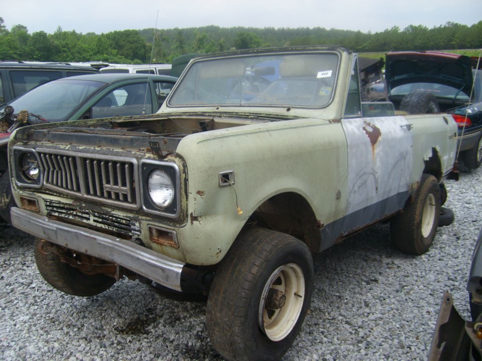 Light green International Harvester Scout II convertible with rust damage and body filler, viewed from the front three-quarter angle