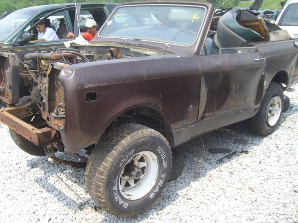 Brown convertible SUV, front end removed, in junkyard
