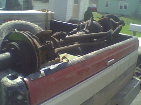 1995 Ford F-150 - A 1995 Ford F-150 truck bed is filled with various suspension components and a spare tire.