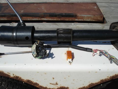 1979 Ford Bronco - A disassembled steering column with its turn signal switch and wiring is laid out on a white surface.