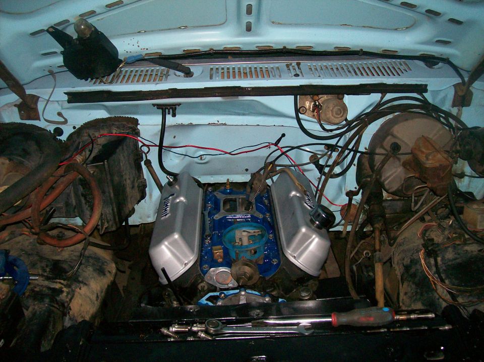 engine bay with blue motor, silver valve covers, and lots of wiring