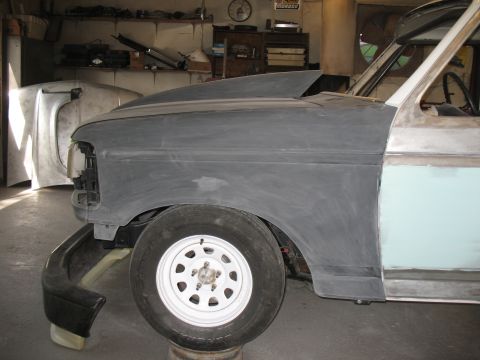 1994 Ford F-150 - A partially prepped Ford truck body sits in a workshop, awaiting further bodywork.