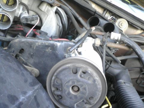 1986 Ford Bronco - Close-up view of engine components including the power steering pump and throttle body.