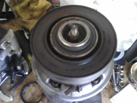 1986 Ford Bronco - A close-up view of a pulley assembly, likely a car part, with visible mechanical components and surrounding hardware.