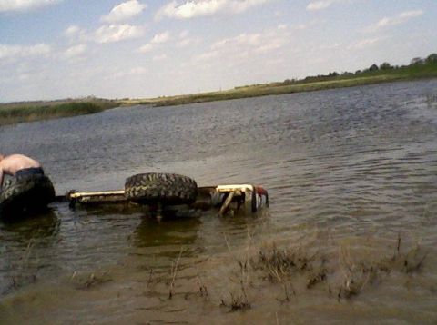 1990 Ford Bronco - A vehicle is stuck in the water with only part of it visible above the surface.