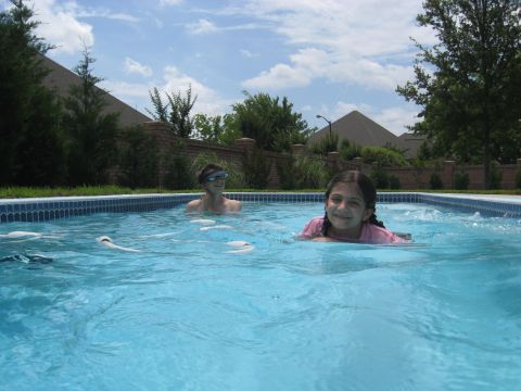1978 Ford Bronco - Two children enjoy a sunny day swimming in a backyard swimming pool.
