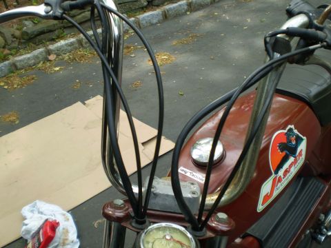 1981 Garelli Rally Sport - Close-up view of a motorcycle's handlebars and fuel tank, showing control cables and a prominent Jasper sticker.
