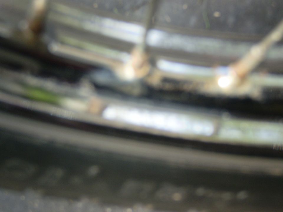 Motorcycle wheel rim with spokes and tire detail, blurry