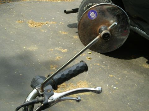 1981 Garelli Rally Sport - Close-up of a motorcycle's handlebar and mirror assembly, showing wear and a sticker on the mirror.