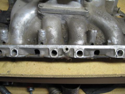 1963 Ford Galaxie - Close-up of an aluminum intake manifold, showing numbered ports and visible casting information.
