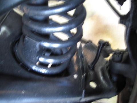 1963 Ford Galaxie - A close-up view of a vehicle's suspension system, showing a coil spring and associated hardware.