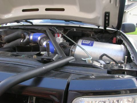 1996 Ford Bronco - Aftermarket intake system installed in the engine bay, blue silicone hoses and a large air filter.