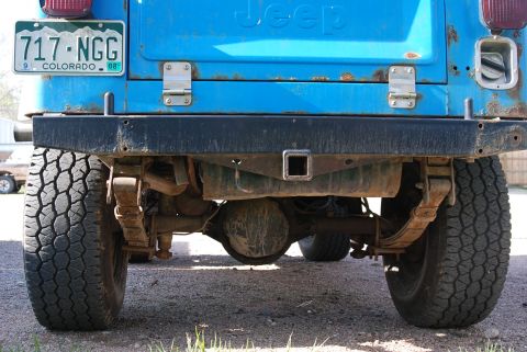 1981 Jeep CJ7 - The rear suspension and drivetrain components of a blue Jeep are visible, along with a Colorado license plate.