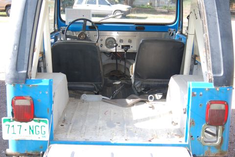 1981 Jeep CJ7 - The interior of a blue 1981 Jeep CJ7 shows black seats, a metal floor, and dashboard gauges.