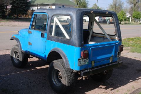 1981 Jeep CJ7 - This blue 1981 Jeep CJ7 is shown from the rear, a black hardtop and an interior roll cage.
