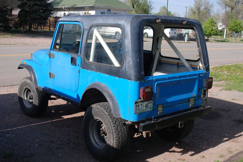 Blue 1981 Jeep CJ7 rear view with roll cage visible