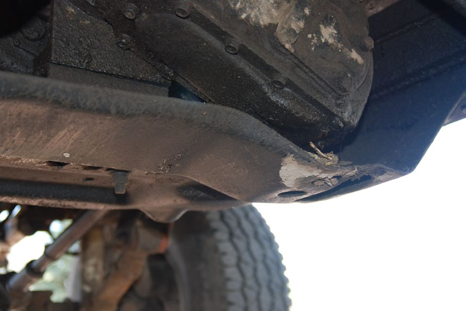 Underside view of vehicle frame and suspension with Supermotors logo