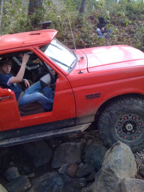 1989 Ford Bronco - 1989 Ford Bronco tackling a challenging off-road trail with large rocks.