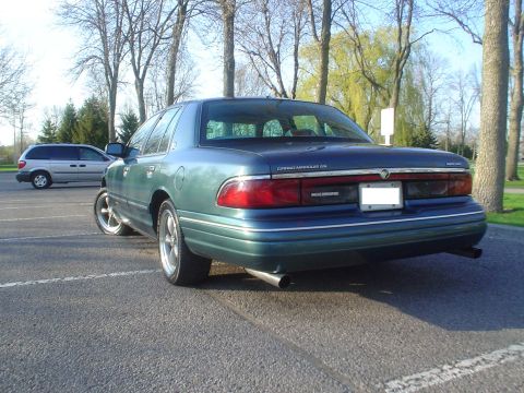 1996 Mercury Grand Marquis - A green Mercury Grand Marquis is parked in a lot, with another vehicle in the background.