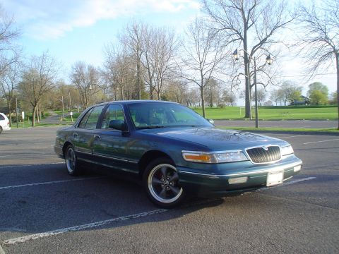 1996 Mercury Grand Marquis - A dark green 1995 Mercury Grand Marquis is parked in a lot on a sunny day.