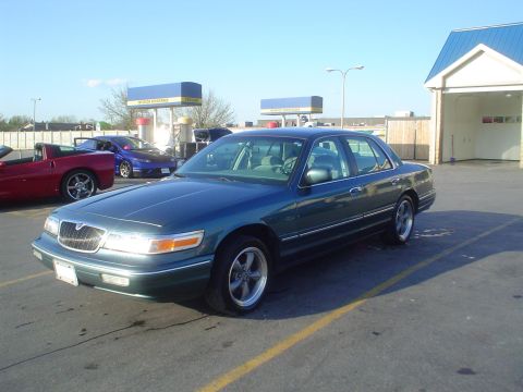 1996 Mercury Grand Marquis - 1996 Mercury Grand Marquis parked at a gas station with other vehicles in the background.