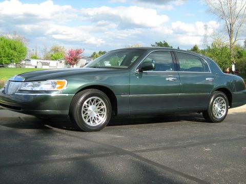 1988 Mercury Grand Marquis - This green sedan, likely a 2001 Lincoln Town Car, is shown from the front three-quarter angle.